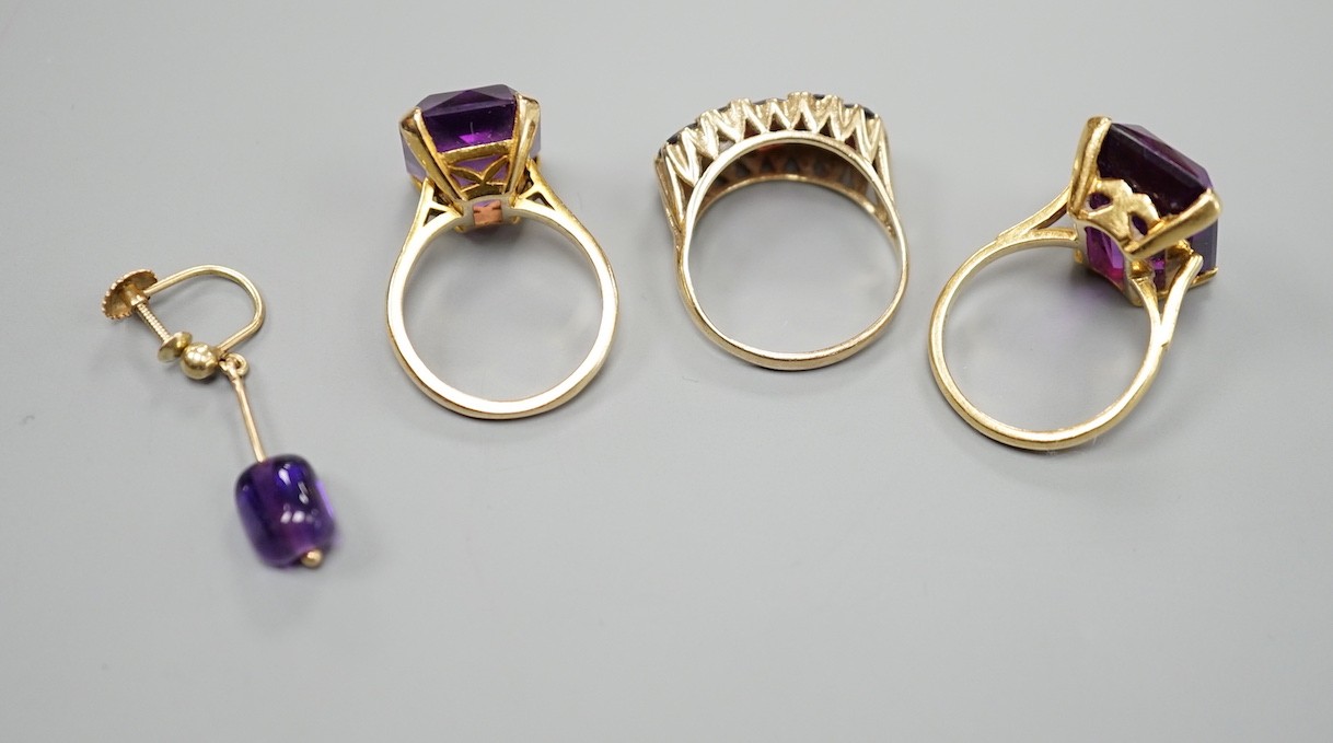 An 18ct and emerald cut synthetic colour change corundum set dress ring, size N, gross weight 10.3 grams, a 9ct gold and amethyst ring, a 9ct gold and three stone garnet set ring, gross 9.9 grams